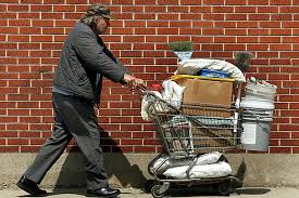 Homeless man pushing a shopping cart with all his belongings